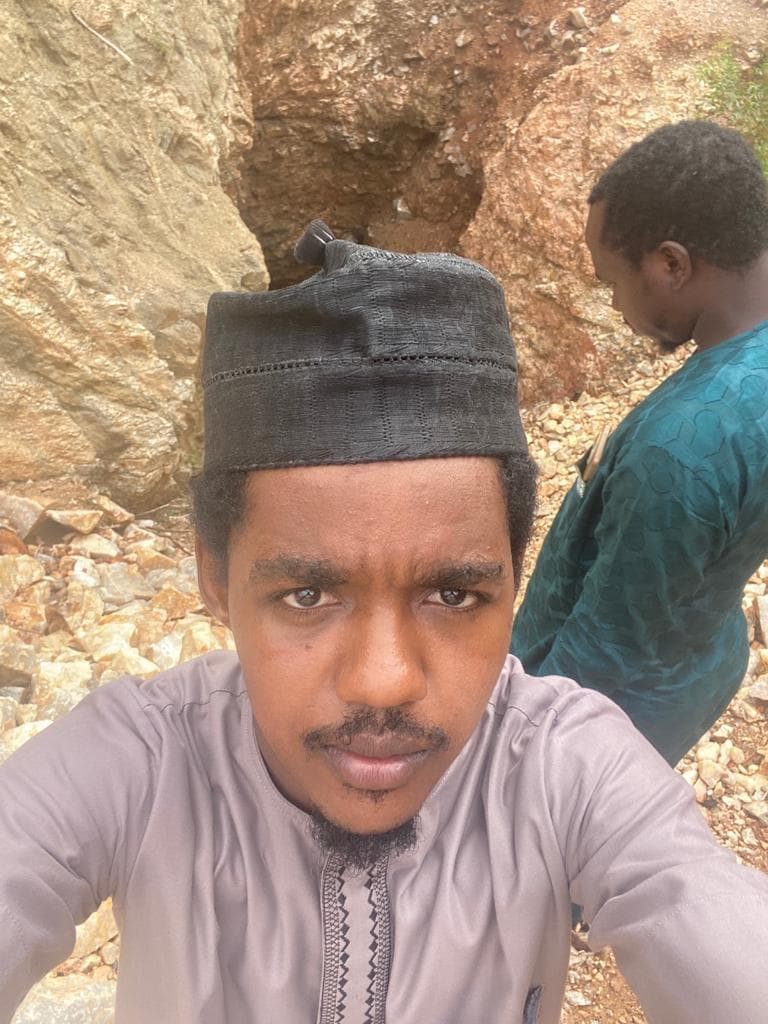 Selfie of Maharaz at an excavation pit with a worker behind him